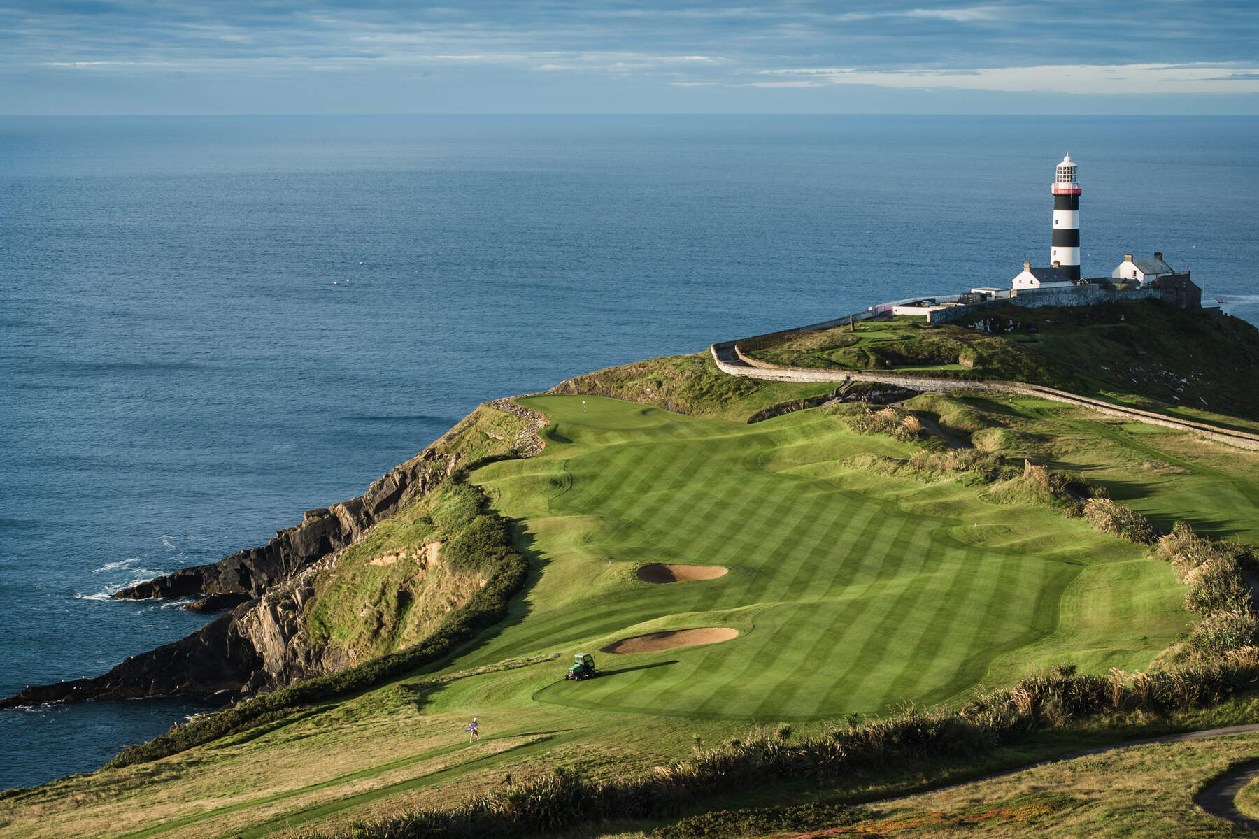 Golfers tackle Hole 4, 'Razor's Edge', at Old Head Golf Links, Kinsale, Co. Cork, Ireland, with dramatic ocean views