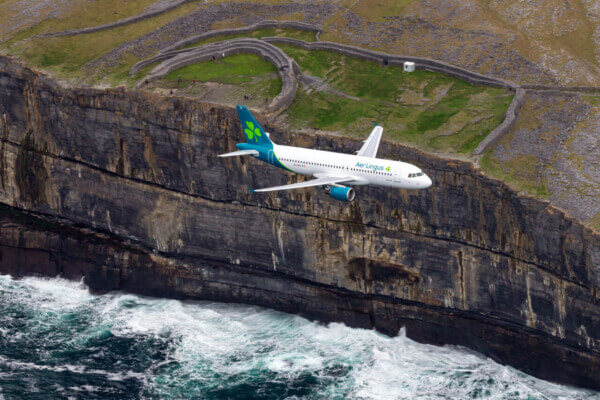 Aeroplane soars over Ireland's stunning Cliffs of Moher, County Clare, showcasing breathtaking Atlantic coastline views