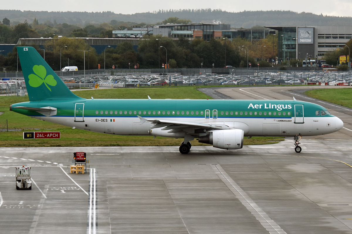 Aer Lingus plane on tarmac: green and white aircraft with shamrock logo.